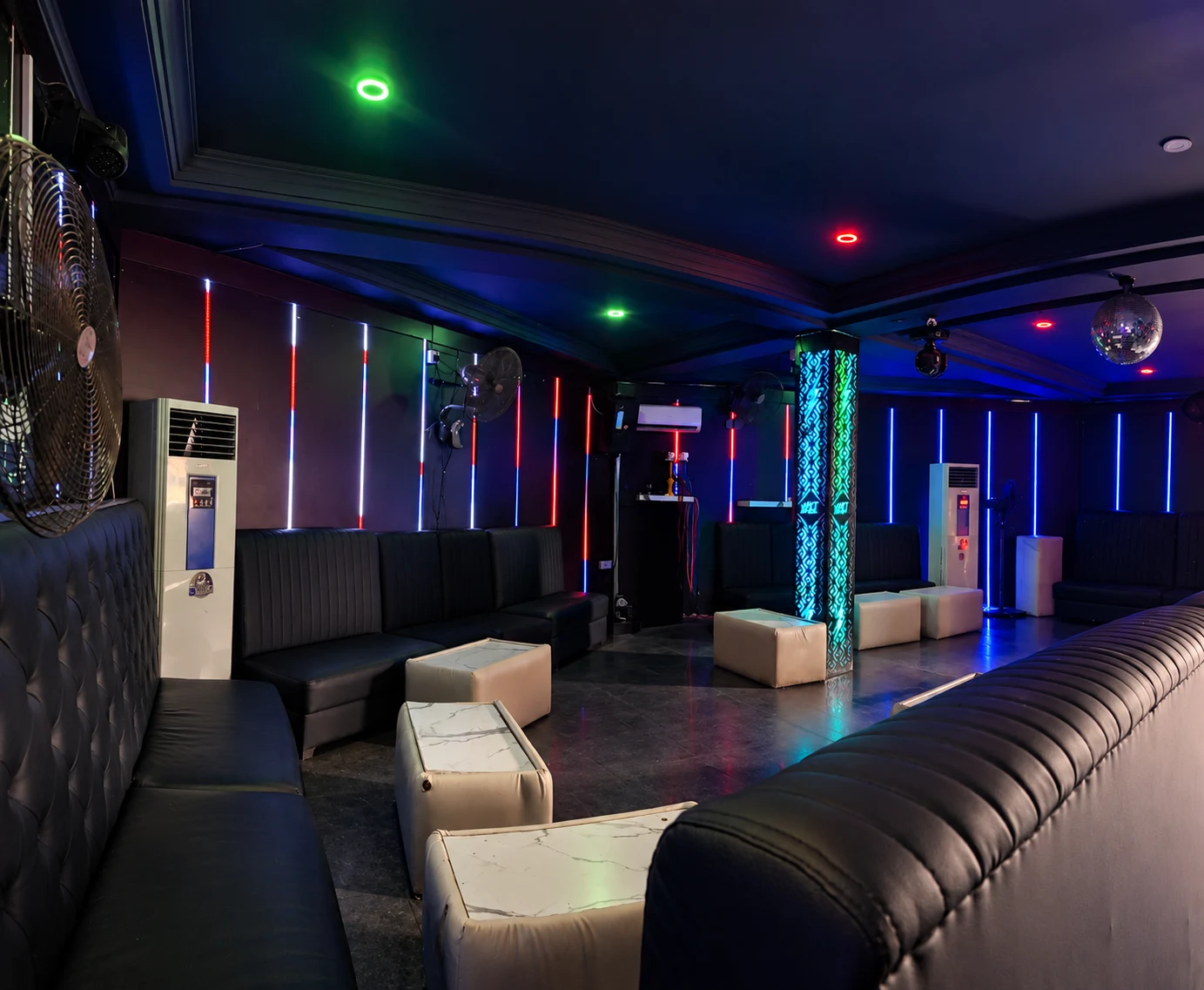 Lounge space with vertical red and blue LED lighting and a disco ball