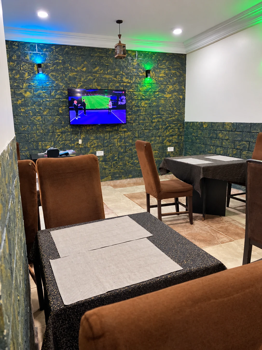 Restaurant dining tables beneath coloured accent lighting