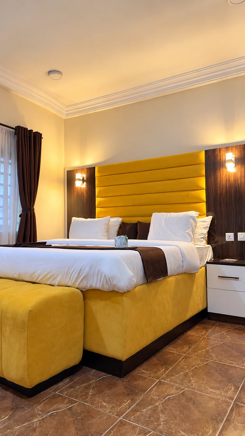 Suite Room yellow upholstered bed and bedside table